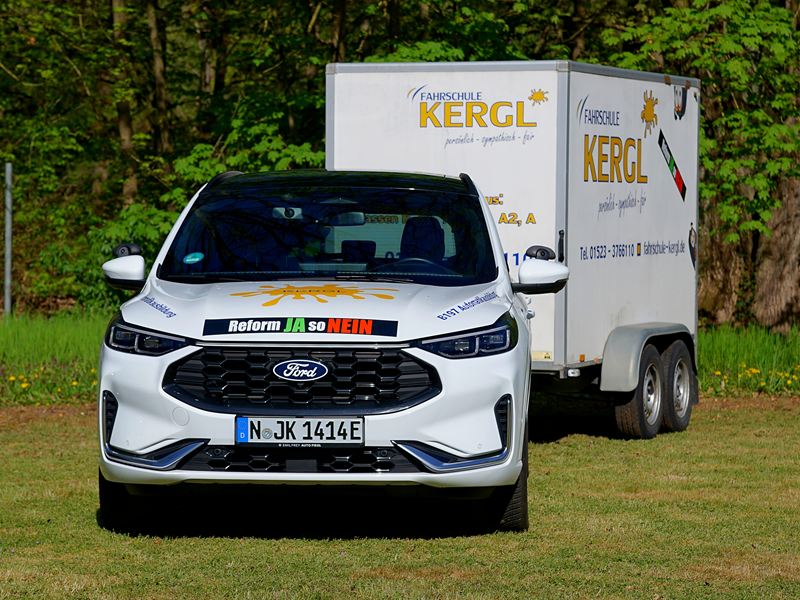 Weißer Ford Kuga mit dem großen Anhänger der Fahrschule Kergl